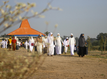 A group of people performing Hajj rituals in an open field